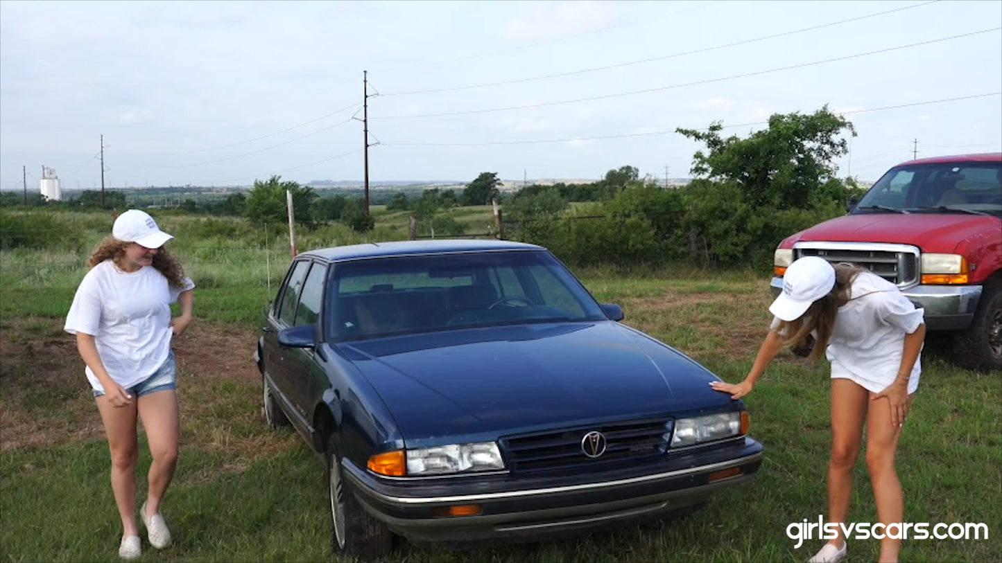 2 aspiring models pose and jump on a car